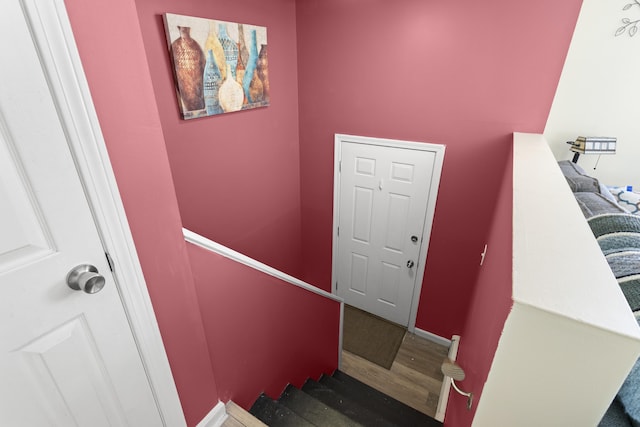 stairway featuring baseboards and wood finished floors