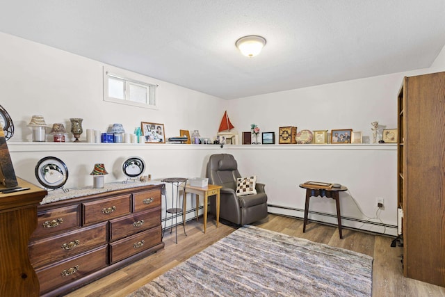 sitting room featuring a baseboard radiator and wood finished floors