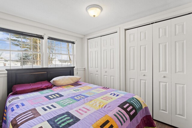 bedroom with multiple closets and a textured ceiling