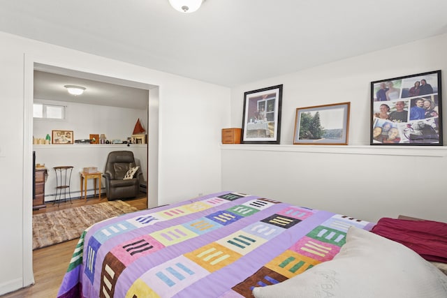 bedroom featuring wood finished floors and a baseboard radiator