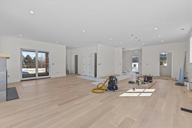 workout area with recessed lighting, baseboards, light wood-style flooring, and a fireplace