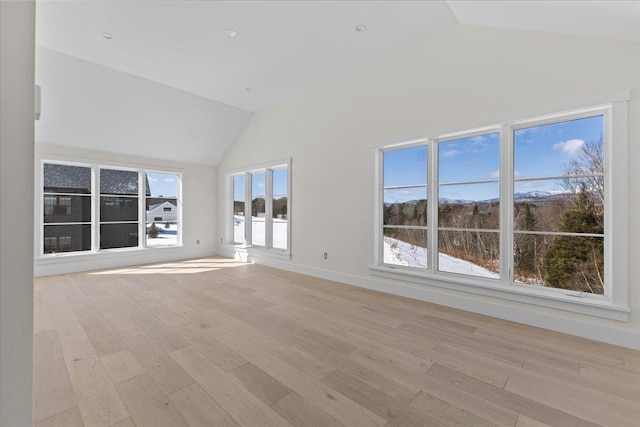 unfurnished living room with lofted ceiling, baseboards, and light wood finished floors