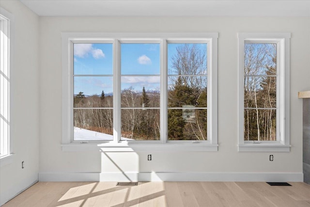 interior space with visible vents, baseboards, and wood finished floors