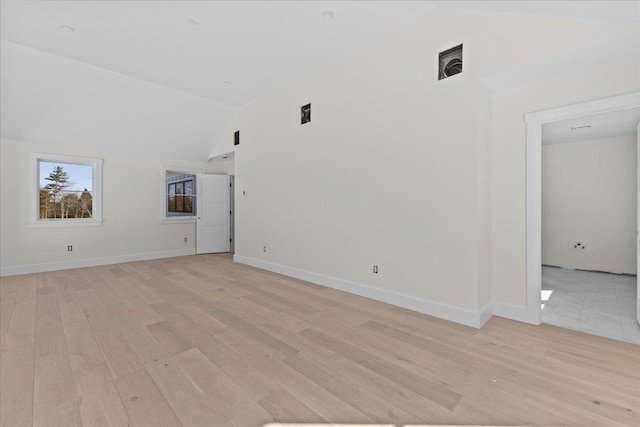 interior space with vaulted ceiling, light wood-style flooring, and baseboards