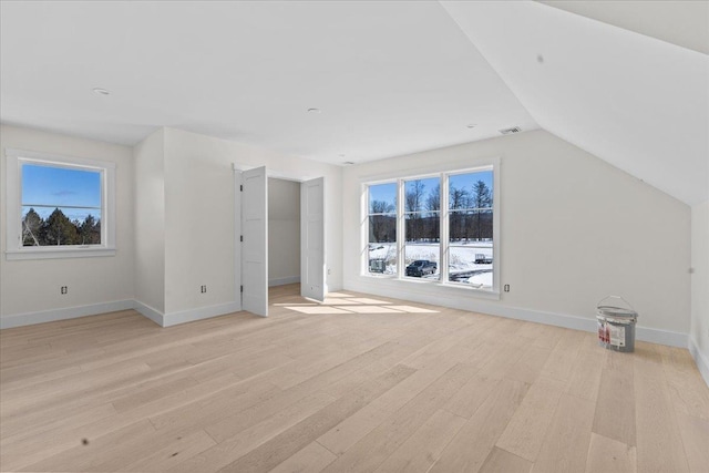 bonus room with visible vents, baseboards, light wood finished floors, lofted ceiling, and a healthy amount of sunlight