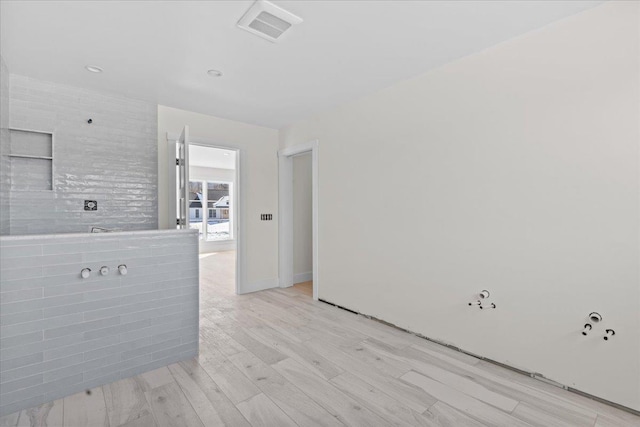 spare room featuring visible vents and light wood-style flooring