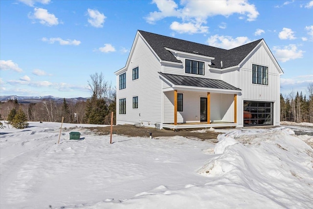 modern farmhouse featuring a standing seam roof, covered porch, a shingled roof, a garage, and board and batten siding