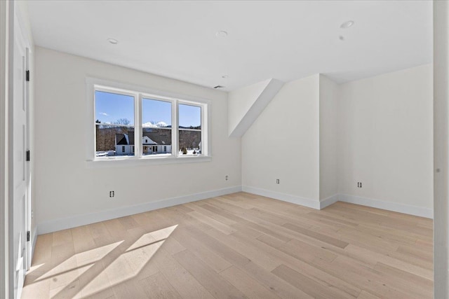 bonus room with baseboards and light wood-style flooring