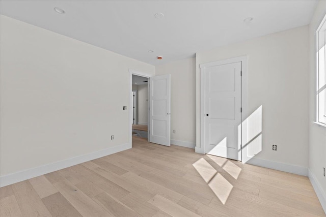 spare room featuring baseboards and light wood-type flooring