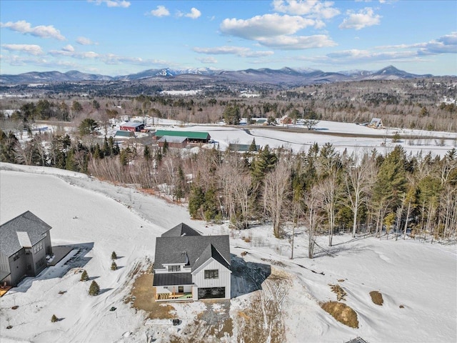 snowy aerial view featuring a mountain view