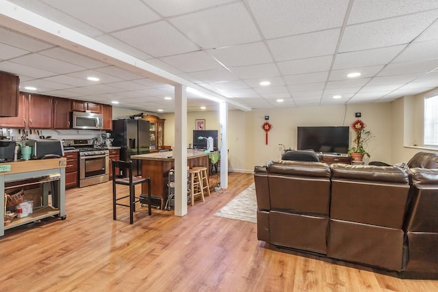 living room with recessed lighting, light wood-type flooring, and a paneled ceiling