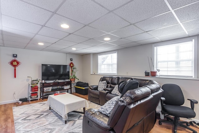 living area with recessed lighting, baseboards, a paneled ceiling, and light wood-style flooring