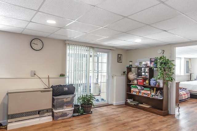 miscellaneous room with wood finished floors, baseboards, and a drop ceiling