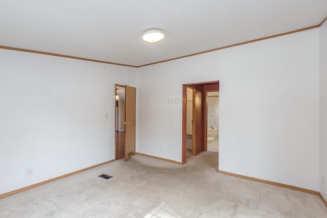 unfurnished room with ornamental molding, baseboards, visible vents, and light carpet