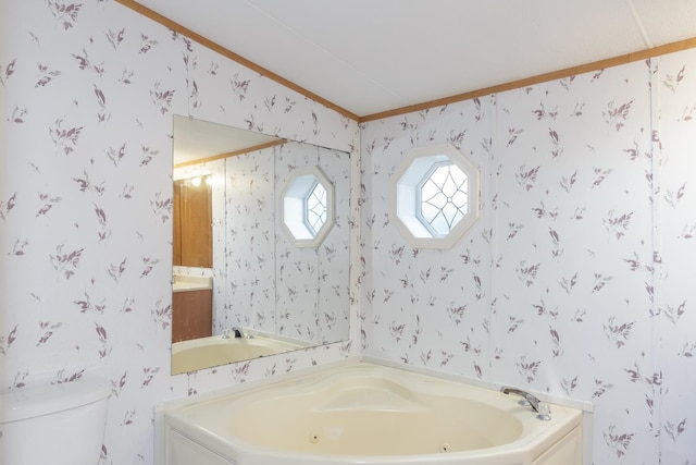 bathroom with wallpapered walls, a jetted tub, and toilet