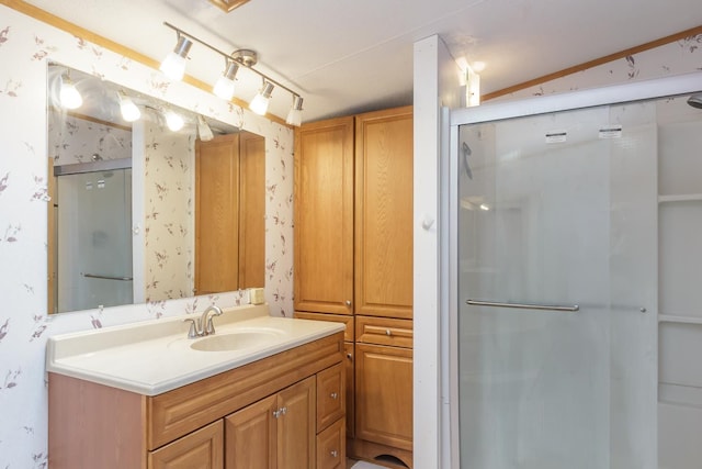 full bath with a stall shower, vanity, and wallpapered walls