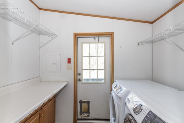 laundry room featuring electric panel, cabinet space, washing machine and dryer, and crown molding