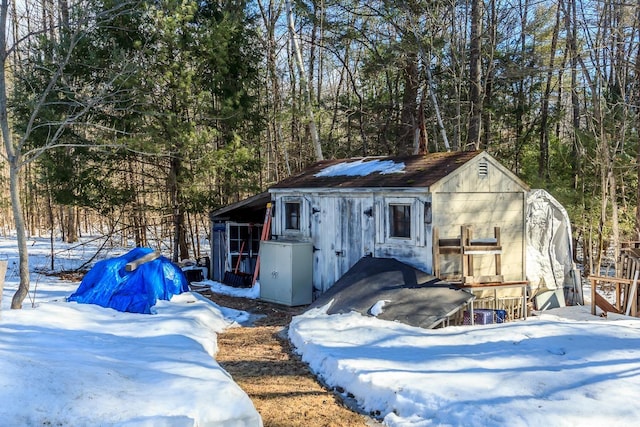 snow covered structure featuring an outdoor structure