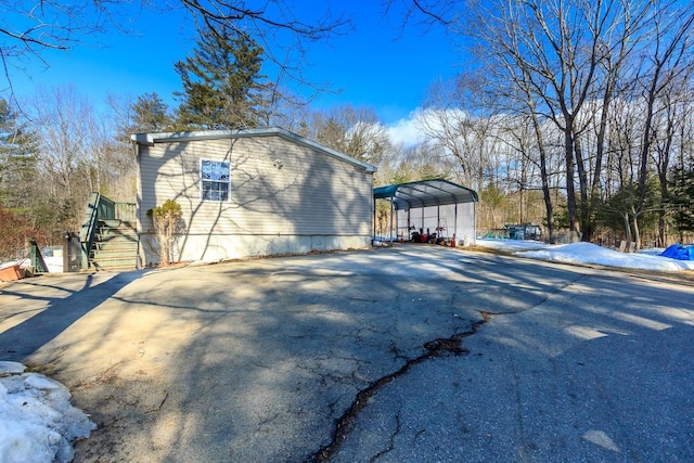 view of property exterior with a carport and aphalt driveway