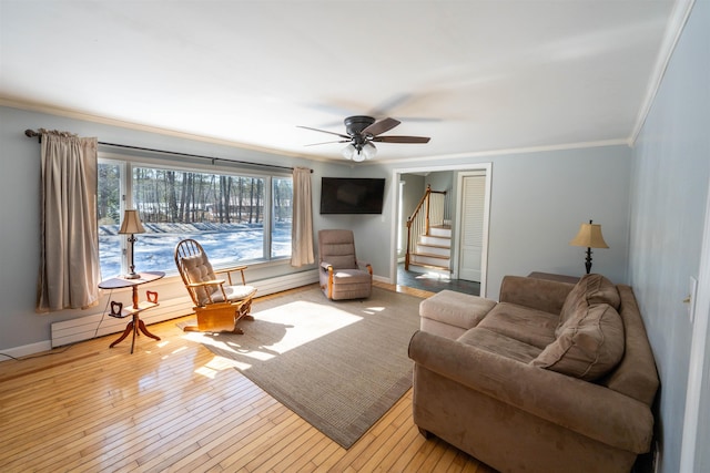 living room featuring stairway, crown molding, baseboards, and hardwood / wood-style flooring