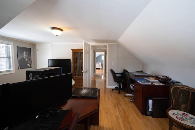 office with light wood-style floors and vaulted ceiling