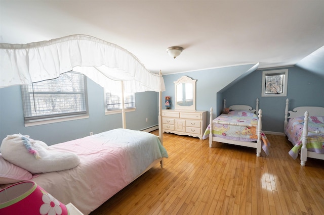 bedroom with a baseboard heating unit, wood-type flooring, and lofted ceiling