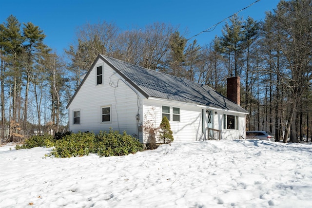 view of snowy exterior with a chimney