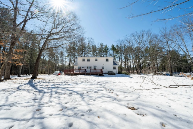 snow covered rear of property with a wooden deck