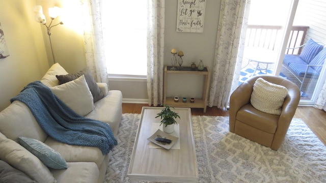 living area with baseboards and wood finished floors