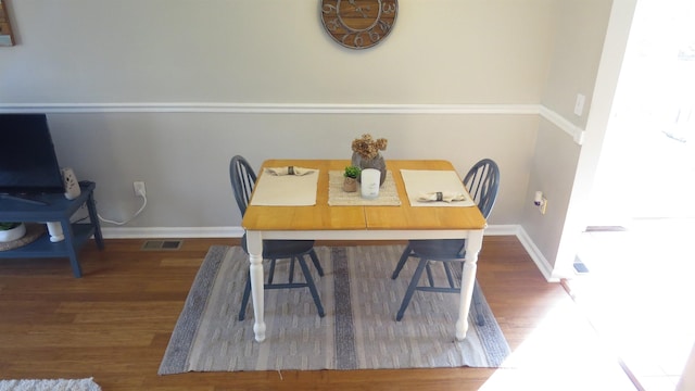 dining space with visible vents, baseboards, and wood finished floors