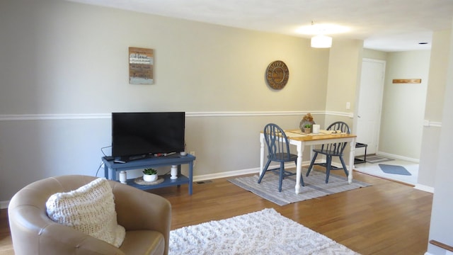 dining area with baseboards and wood finished floors