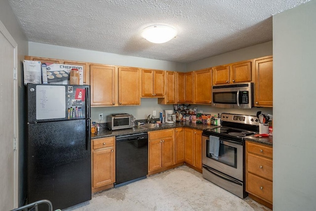 kitchen with dark countertops, a textured ceiling, black appliances, and a sink