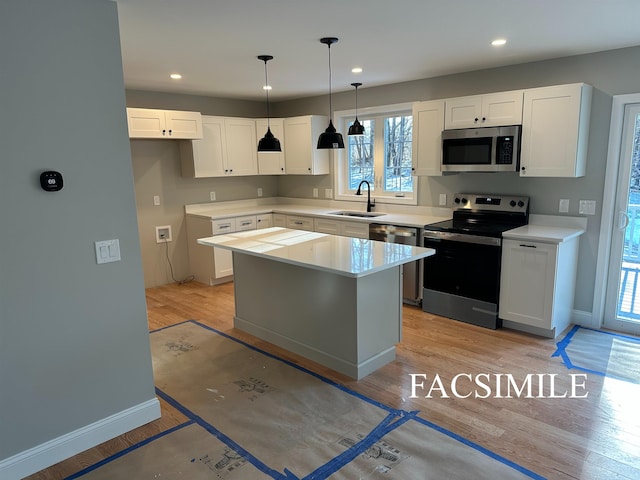 kitchen with appliances with stainless steel finishes, a kitchen island, light wood-type flooring, and a sink