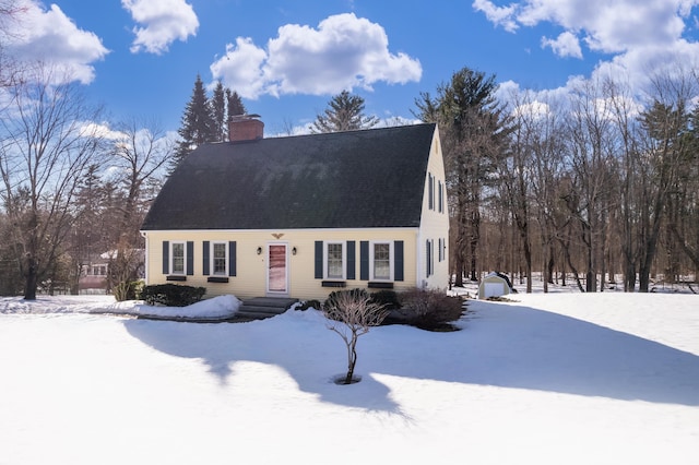 view of front of home featuring a gambrel roof, a chimney, and roof with shingles