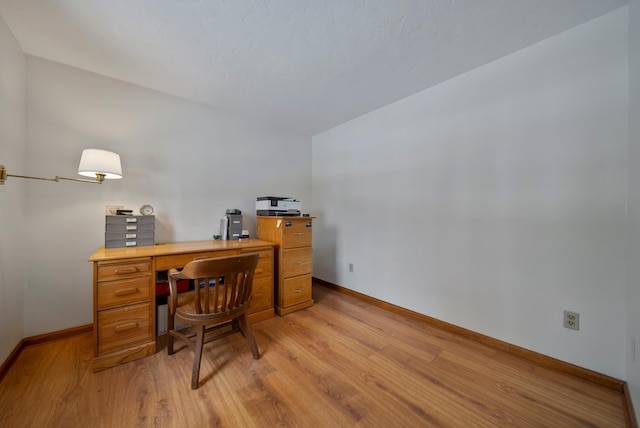 office space with light wood-type flooring and baseboards