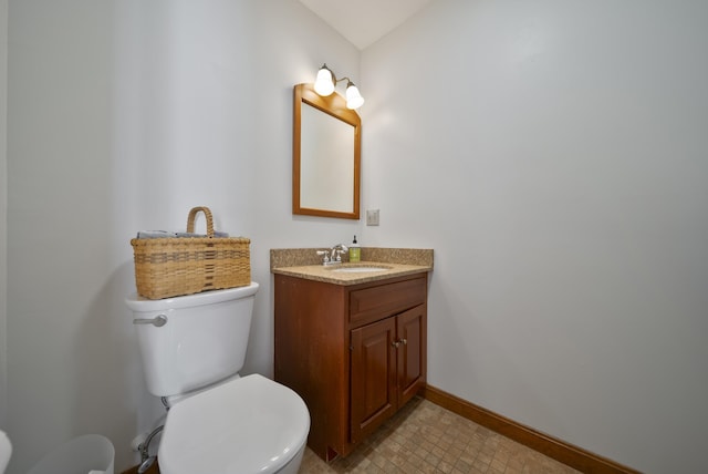 half bath featuring baseboards, toilet, and vanity