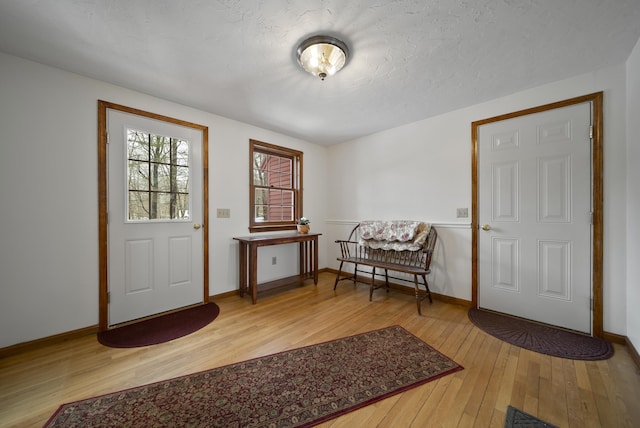 entryway featuring baseboards, a textured ceiling, and hardwood / wood-style floors