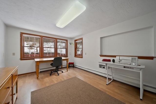 office area featuring a baseboard radiator, a textured ceiling, baseboards, and wood finished floors