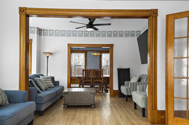 living room featuring light wood-type flooring and a ceiling fan