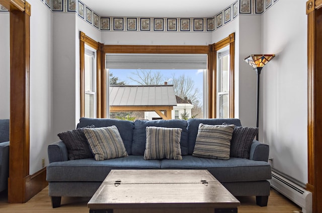 living area with wood finished floors, baseboards, and baseboard heating