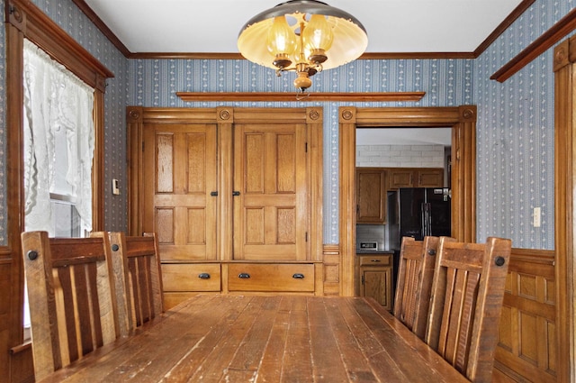 interior space with hardwood / wood-style flooring, a chandelier, crown molding, and wallpapered walls