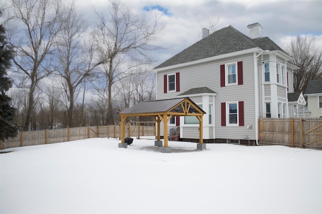 view of front facade with a gazebo, a chimney, and a fenced backyard