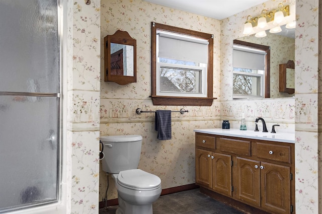 bathroom with toilet, a stall shower, wallpapered walls, baseboards, and vanity