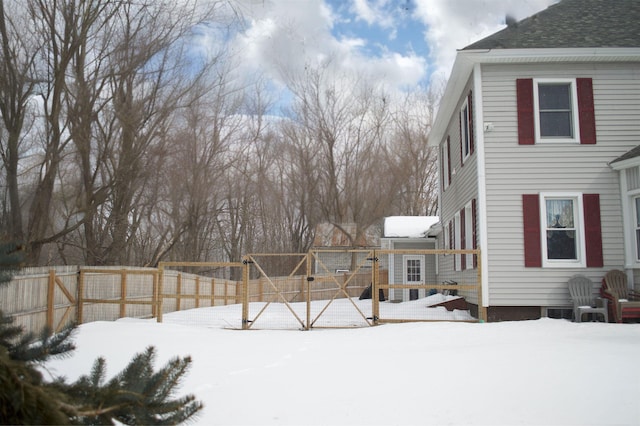 snowy yard with a wooden deck and a fenced backyard