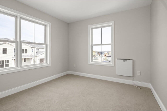 empty room with light colored carpet and baseboards