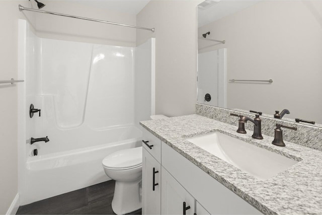 bathroom featuring vanity, bathing tub / shower combination, toilet, and wood finished floors