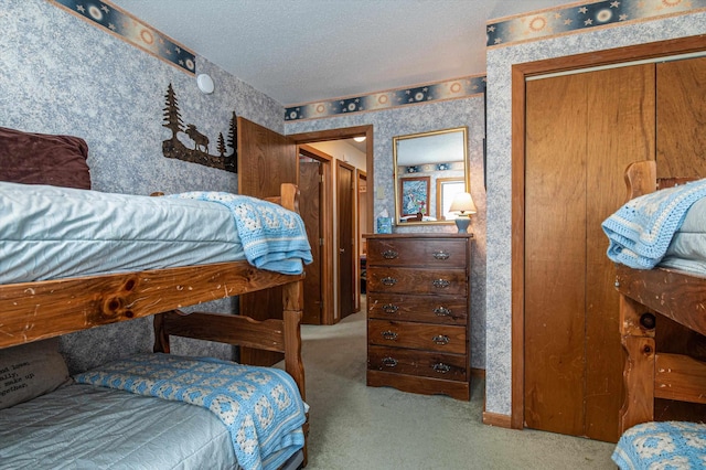 bedroom featuring a textured ceiling, wallpapered walls, and carpet floors