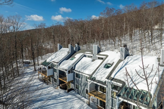 snowy aerial view featuring a forest view