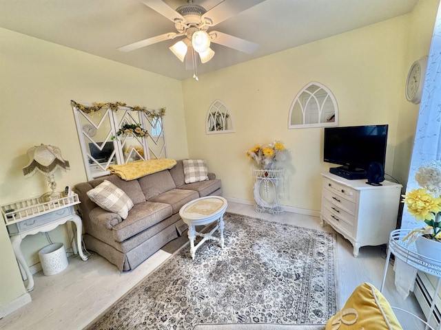 living room with ceiling fan, wood finished floors, baseboards, and a baseboard radiator