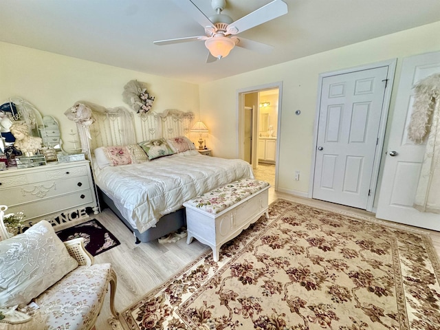 bedroom featuring wood finished floors, ensuite bathroom, and ceiling fan